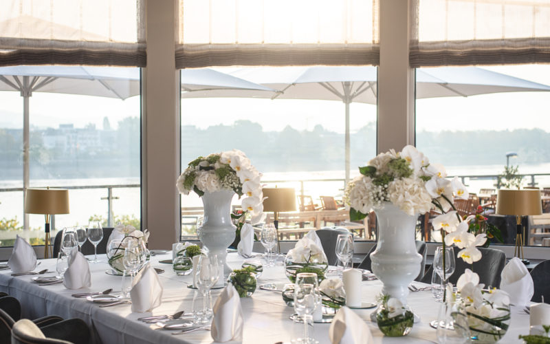 Hochzeitstisch mit Blumensträußen vor Fenster