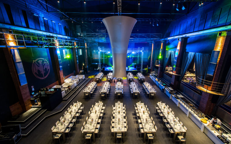 Gala Veranstaltung mit schönen blau/grünen Beleuchtungen Sitzplätzen und gedeckten Tischen