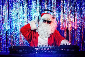 DJ als Weihnachtsmann verkleidet mit Sonnenbrille auf einer Weihnachtsfeier