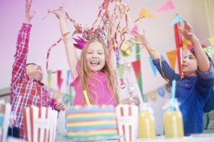 Kinder feiern mit Deko-Papierschlangen und Wimpeln Kindergeburtstag
