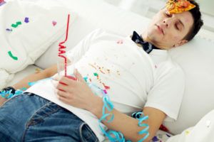 Betrunkener junger Mann liegt auf dem Rücken nach einer Party