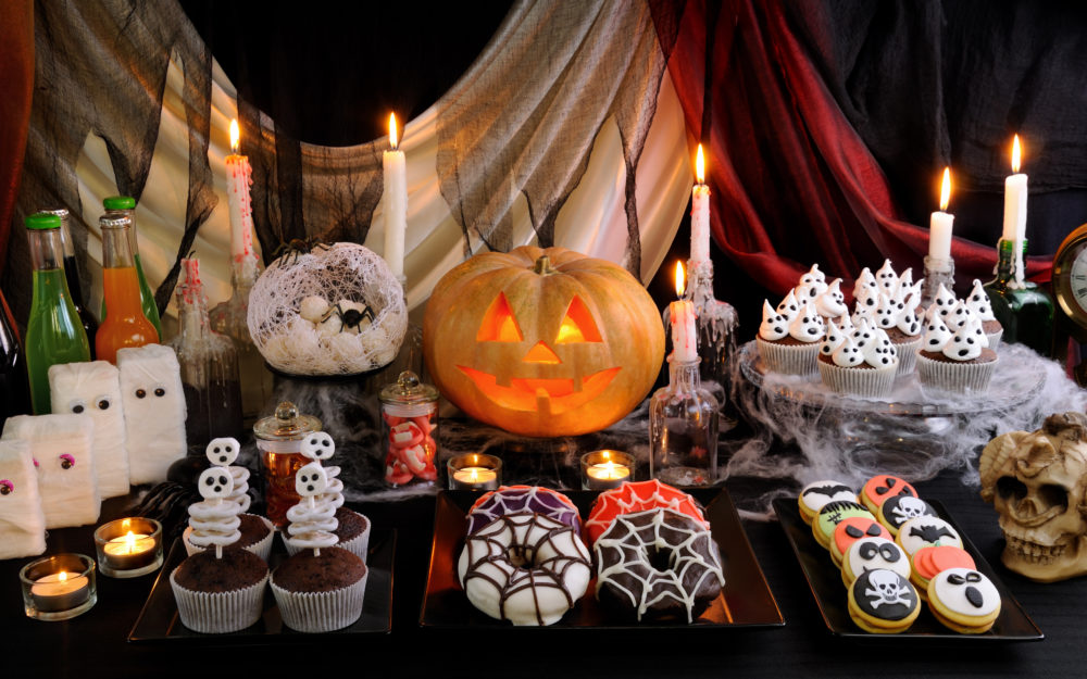 Geschmückter Halloween Tisch als Halloween Süßigkeiten-Buffet mit Kerzen