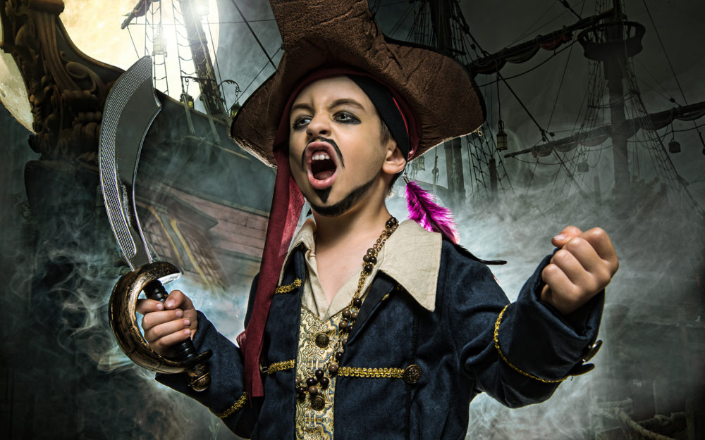Ein Jugendlicher, verkleidet als Pirat mit Säbel in der Hand