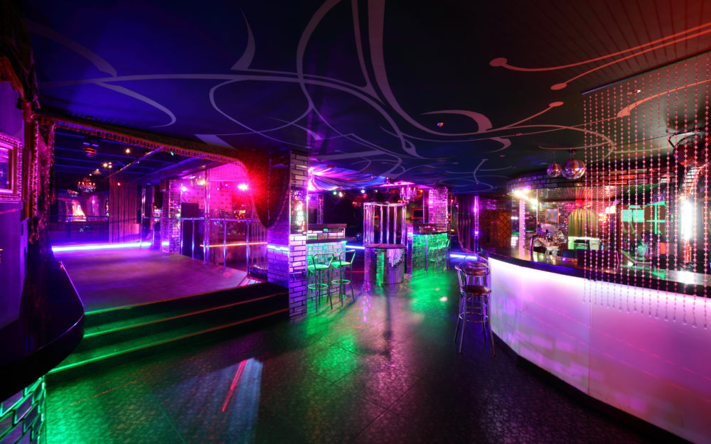 Club mit einer Bar als Eventlocation mit Lichtdekoration in Lila und Grün als ideale Räumlichkeit
