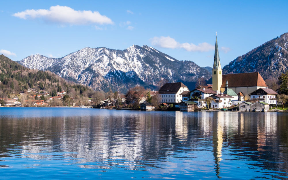 Herrlicher Blick vom Tegernsee auf eine Kirche in blauer Stimmung