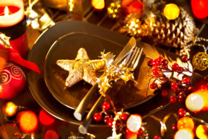 Weihnachtlich dekorierter Tisch mit Tellern, Besteck, Kerzen und Sternen