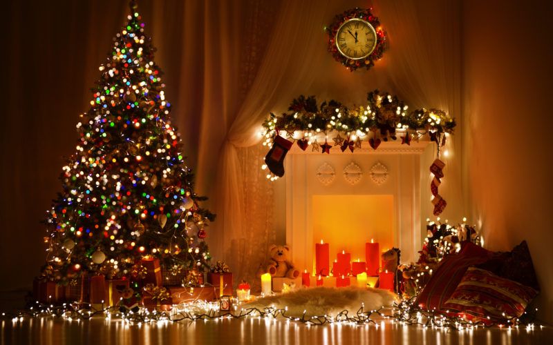 Blick in einen weihnachtlich geschmückten Raum mit Lichtdekoration, Kerzen und einem Weihnachtsbaum