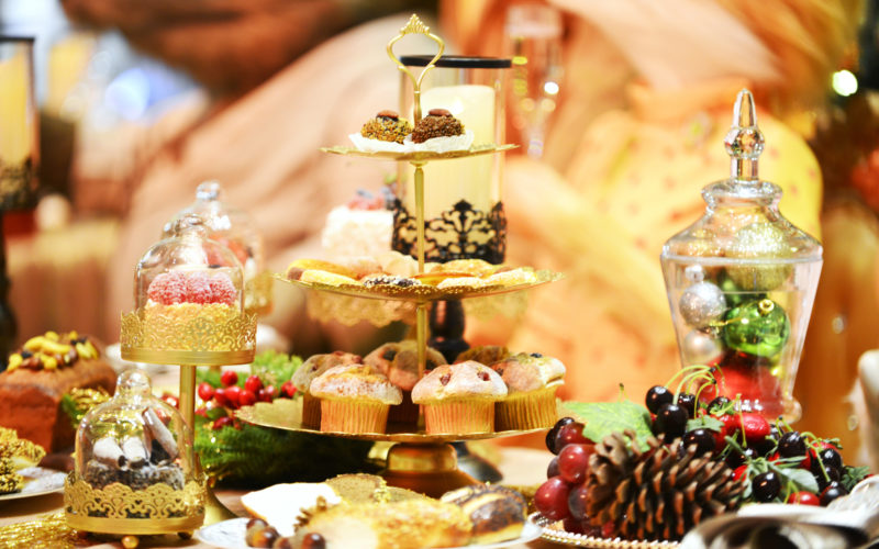 Weihnachtsfeier in Duisburg; Weihnachtlich dekorierter Tisch mit einer Etagere auf der verschiedenes Gebäck liegt