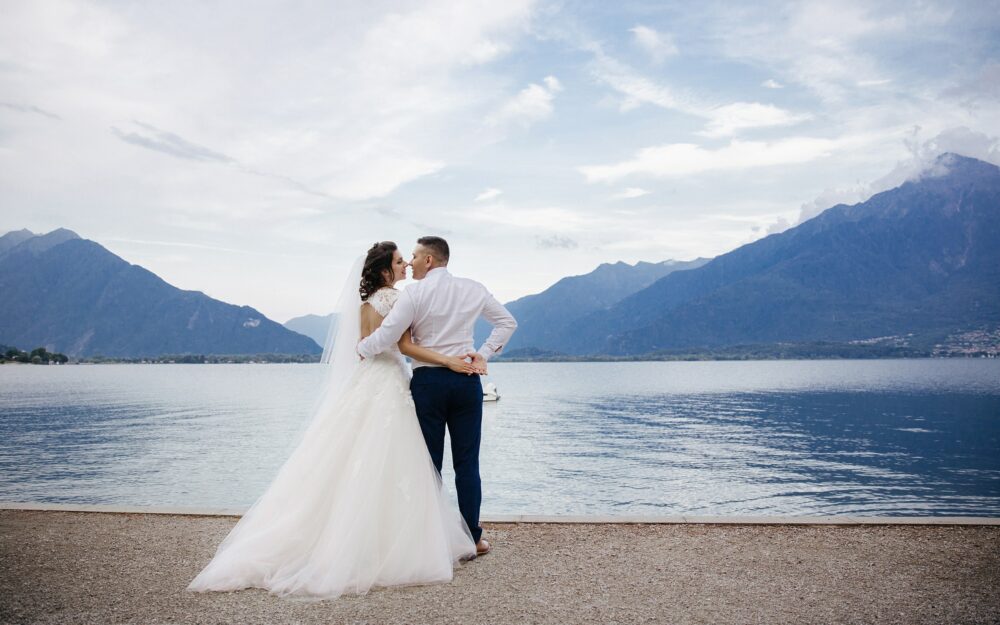 Brautpaar an einem See mit Bergen im Hintergrund