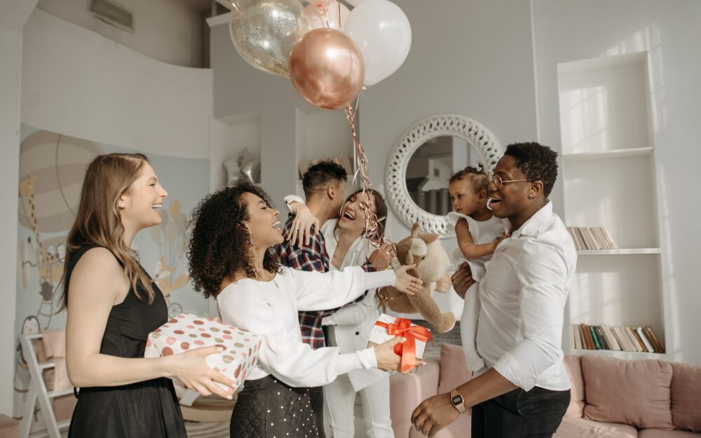 Familie und Freunde feiern mit Ballons und Geschenken die werdenden Eltern