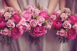 Drei Brautjungfern in rosanem Kleid halten drei pinke Blumensträuße, eventlocations