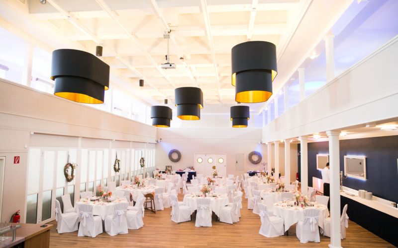Großer heller Saal mit runden weißen Tischen und Stühlen für Hochzeiten oder einen Galaabend, Eventlocations für bis zu 1000 Personen in Hamburg