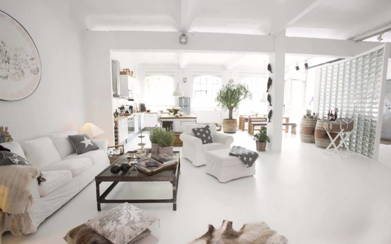 Weißer Raum mit weißen Möbeln und Holztisch; Eventlocations für bis zu 50 Personen in Hamburg