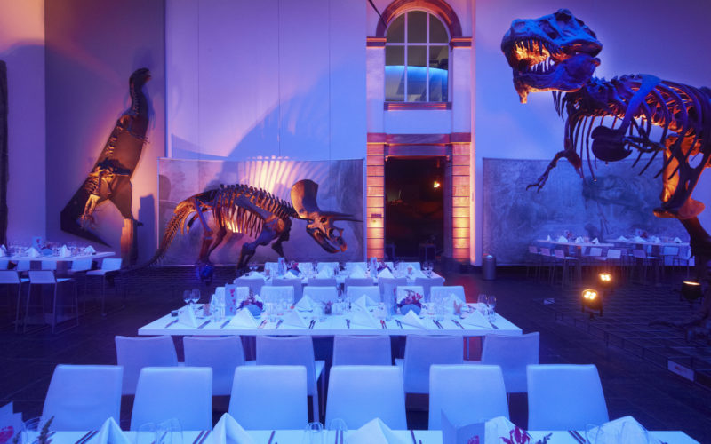 Eventlocations für bis zu 200 Personen in Frankfurt - Gedeckte weiße Tische mit Dinosaurier Skeletten als Deko