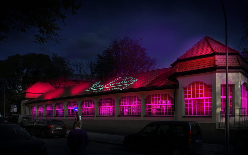 Eine Bar von außen mit pinkem Licht drinnen