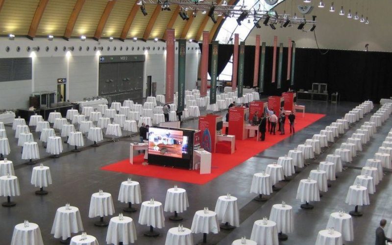 Große Eventhalle mit vielen systematisch angebrachten Stehtischen, Traumhafte Firmenfeiern in Bielefeld
