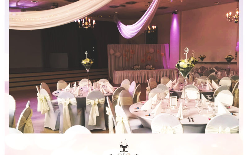 Hochzeitssaal mit weiß gedeckten runden Tischen