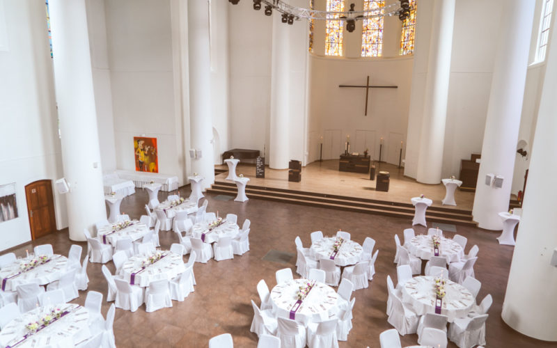 Hochzeitslocation Essen Gelsenkirchen Kreuzeskirche gedeckte Tische in der Kirchen Halle