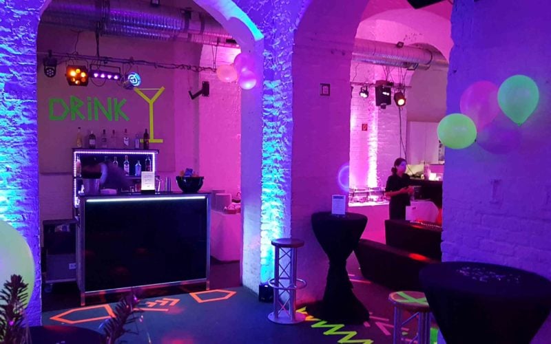 Eventlocation mit Lichttechnik, einer kleinen bar und Tischen; Party in Köln