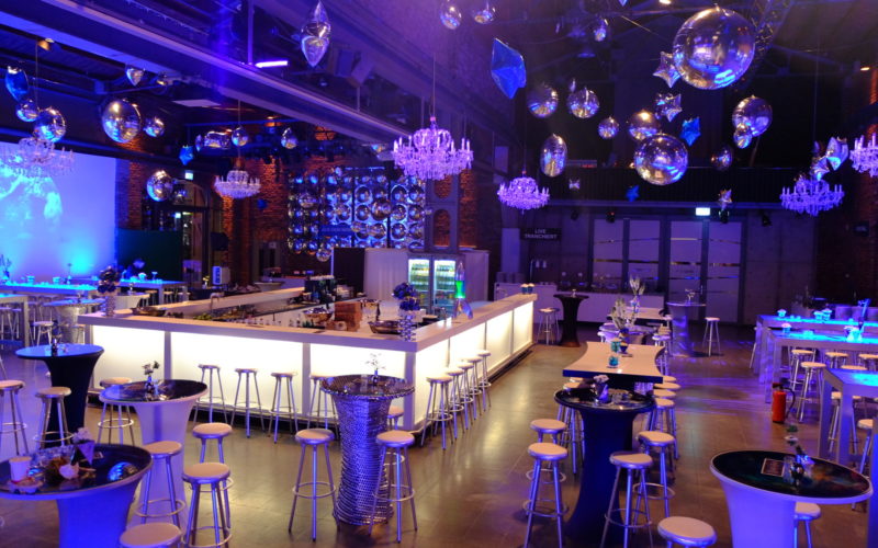 Schicke Location mit Diskokugeln, einer Bar in der Mitte sowie Galatischen und Stühlen; Party in Köln