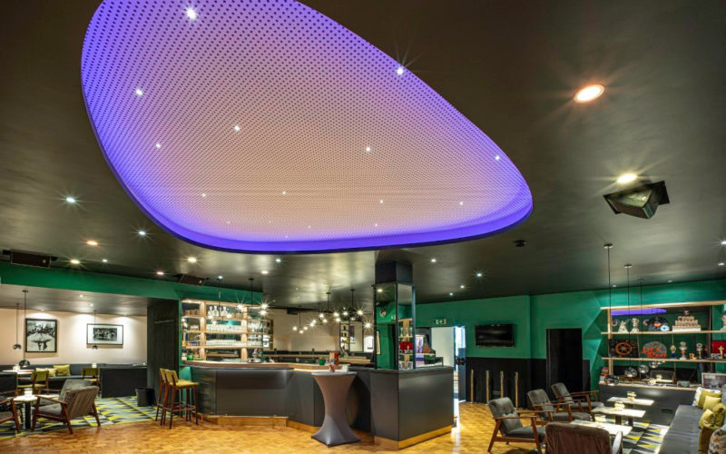 Eventlocation mit Bar und einem großen lila Lichtelement an der Decke, Traumhafte Firmenfeier in Bremen