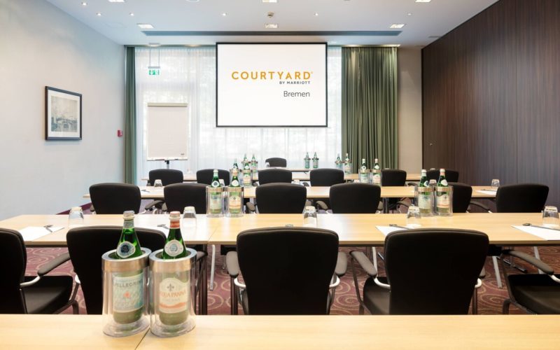 Großer Konferenzraum mit Tischen, Stühlen und einer Leinwand; Produktpräsentation in Bremen