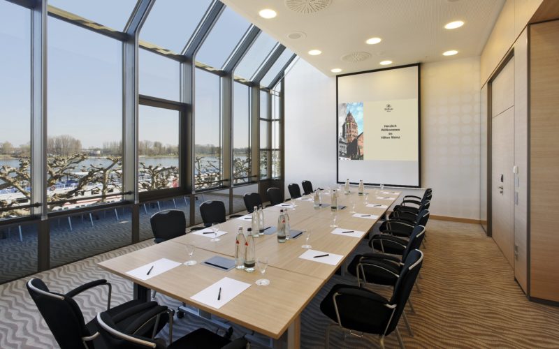 Moderner, Lichtdurchfluteter Raum mit Tisch und Stühlen, Meetingräume deutschlandweit