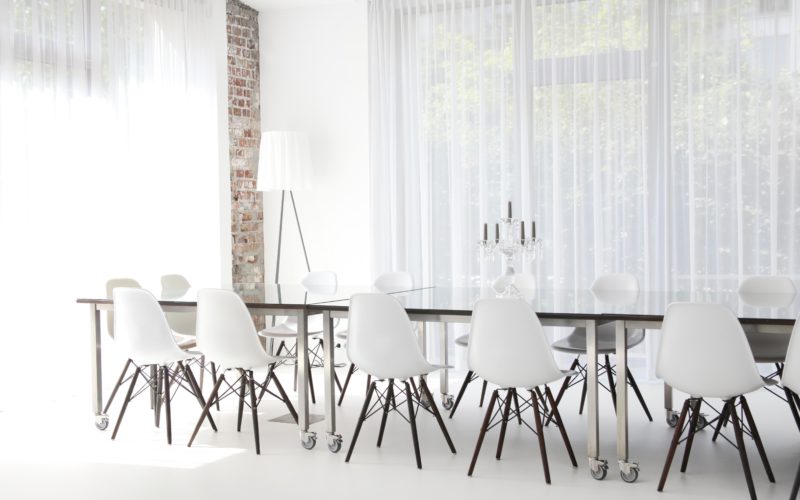 Moderner, heller Raum mit einem großen Tisch und Stühlen