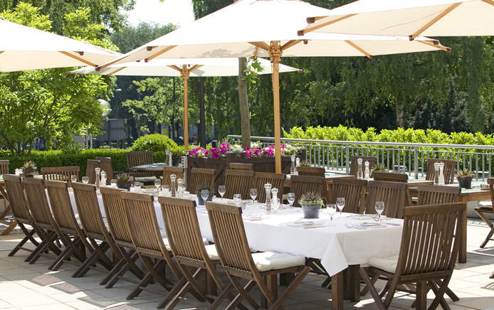Schöne Grünanlage mit Sonnenschirmen, Tischen und Stühlen; Party in Aaachen