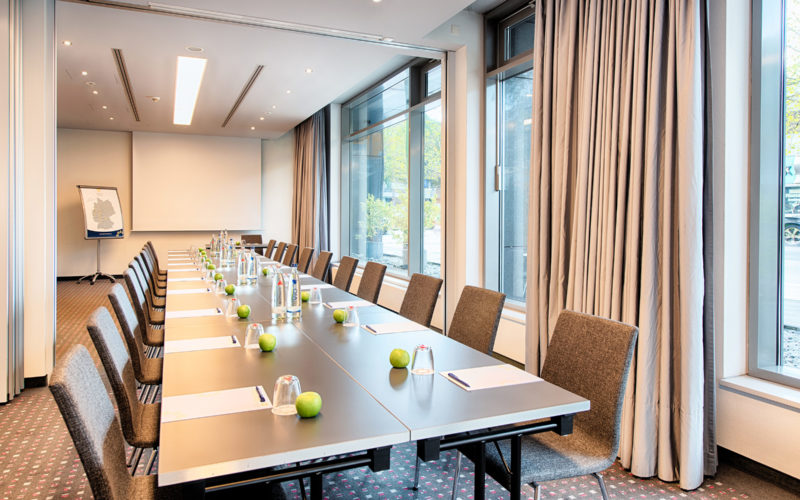 Stilvoller Raum mit großen Fenstern, einem großen Tisch und Stühlen, Meetingraum für Besprechungen, Workshops und Businessevents
