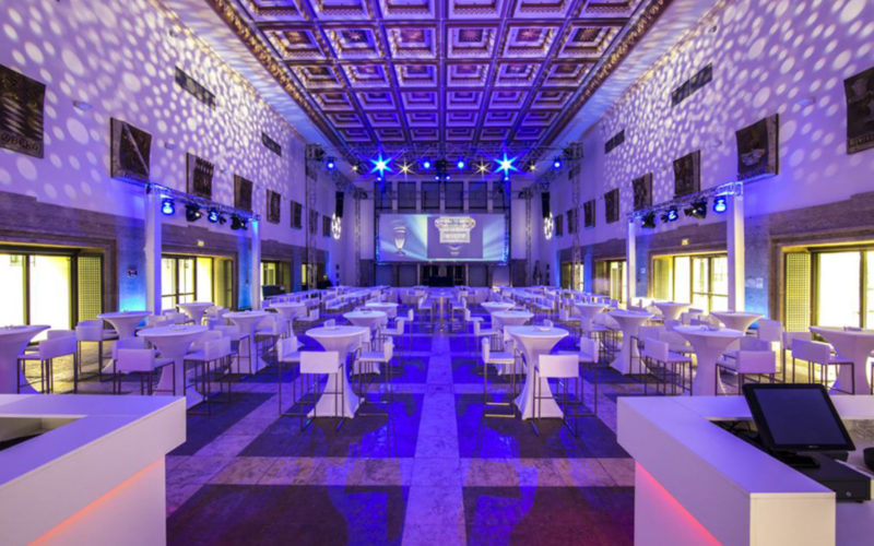 Veranstaltungshallen in München für Ihr Event, große festlich und modern eingerichtete Halle mit lilaner Beleuchtung und weißer Möbilierung