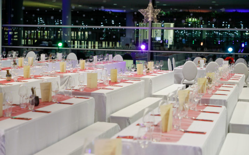 Eventlocation mit weiß dekorierten Tischtafeln; Messehalle in Augsburg