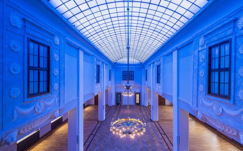 Blau beleuchteter Raum mit hoher Glasdecke; Messehalle in Dresden