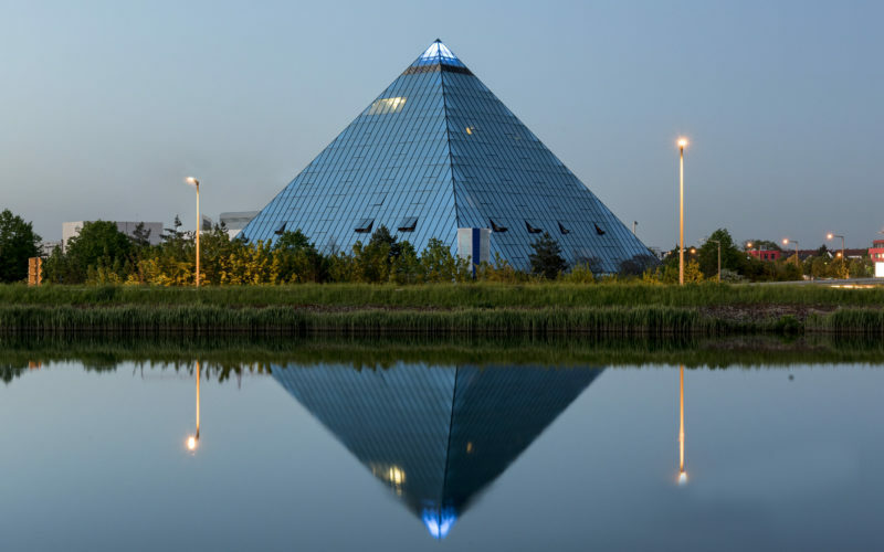 Ein Gebäude in der Form einer Pyramide und ihre Spiegelung in einem Teich