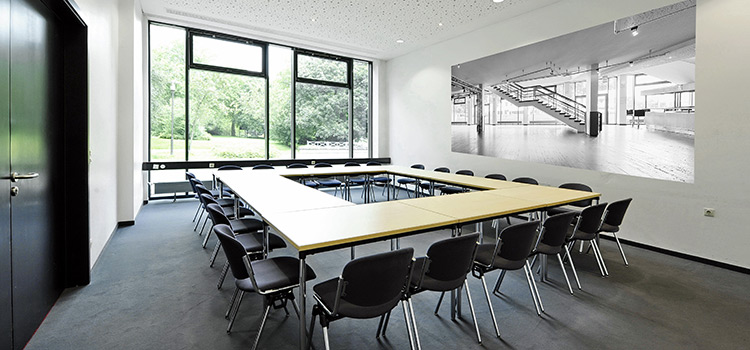 Heller Raum mit Tischen, Stühlen und einer Glaswand; Tagungsraum und Konferenzraum in Solingen