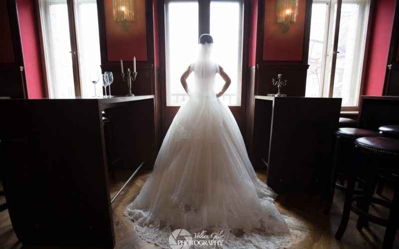 Braut im Hochzeitskleid die aus dem Fenster blickt