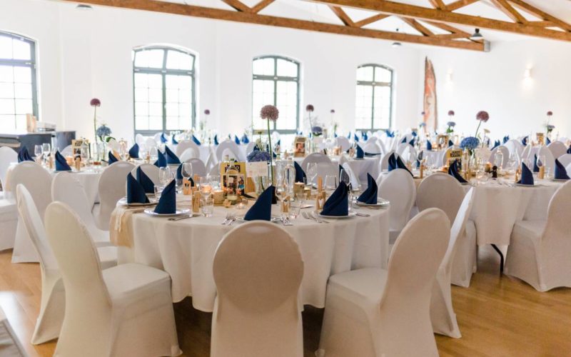 Festlich gedeckte Gala Tische mit weißen Stuhlhussen